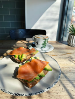 Tosta de aguacate, queso crema y salmón sobre pan de semillas
